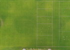 Fußballplatz mit Kindern und Linien von oben, wodurch eine beispielhafte Bebauung gezeigt werden soll.