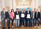 Regierungspräsident Walter Jonas (1.v.l.) mit der Absolventin und den Absolventen Regina Roidl (6.v.l.), Merlin Fuhge (4.v.l.) und Lukas Stangl (4.v.r.) aus dem Landkreis Schwandorf, dem Prüfungsausschussvorsitzenden Stefan Graf (3.v.r.) und Ehrengästen