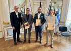 Regierungspräsident Walter Jonas steht neben den Geehrten Helmut Eckl, Alexander Kracun und Xaver Steger, die Urkunden und Medaillen für ihre Lebensrettung entgegennehmen.
