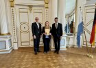 Regierungspräsident Walter Jonas steht mit der Geehrten Fanny Kretschmer und Ehrengast im Großen Sitzungssaal der Regierung der Oberpfalz.